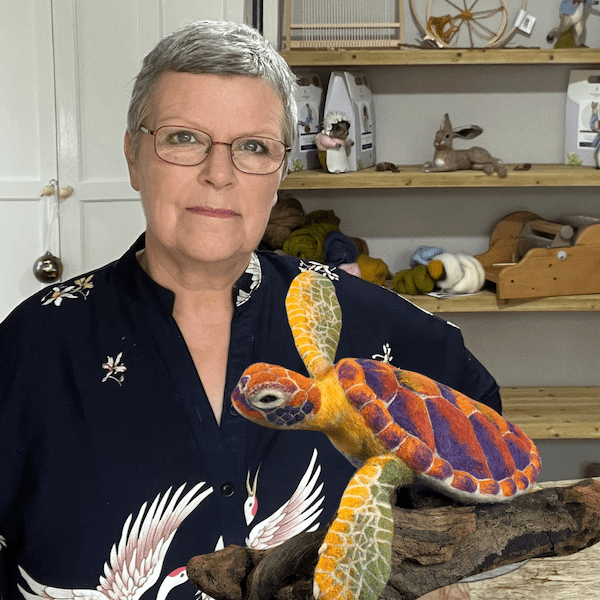 Stephanie Lester holding her gree sea turtle sculpture